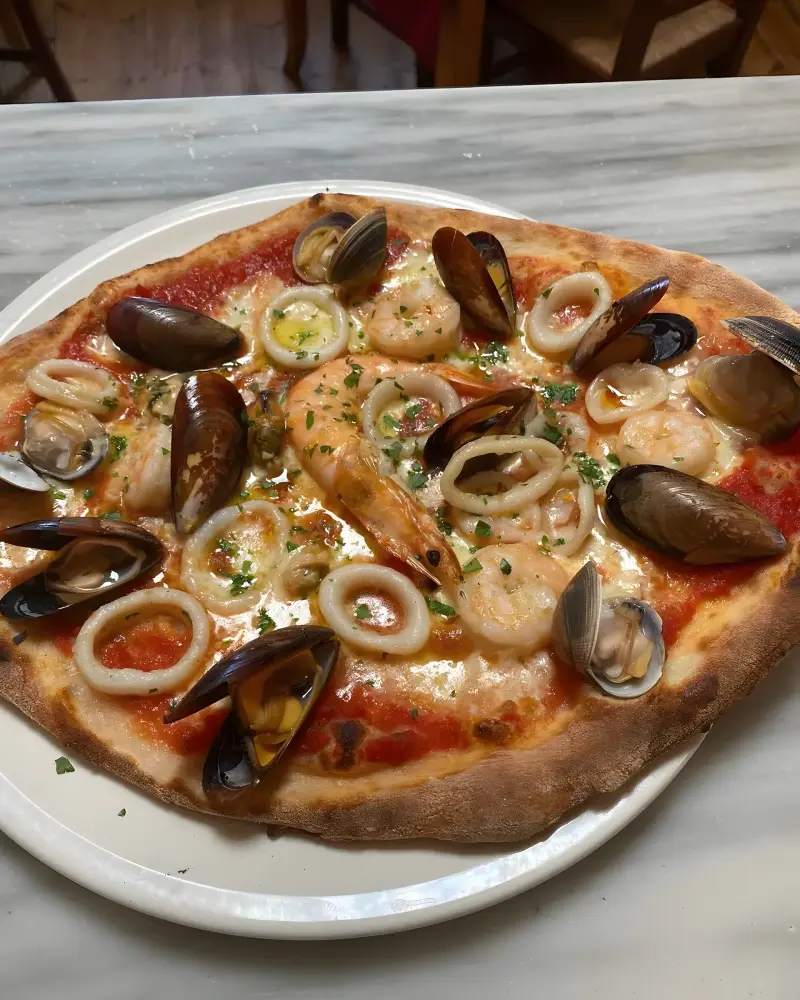 A seafood pizza topped with shrimp, mussels, clams and calamari