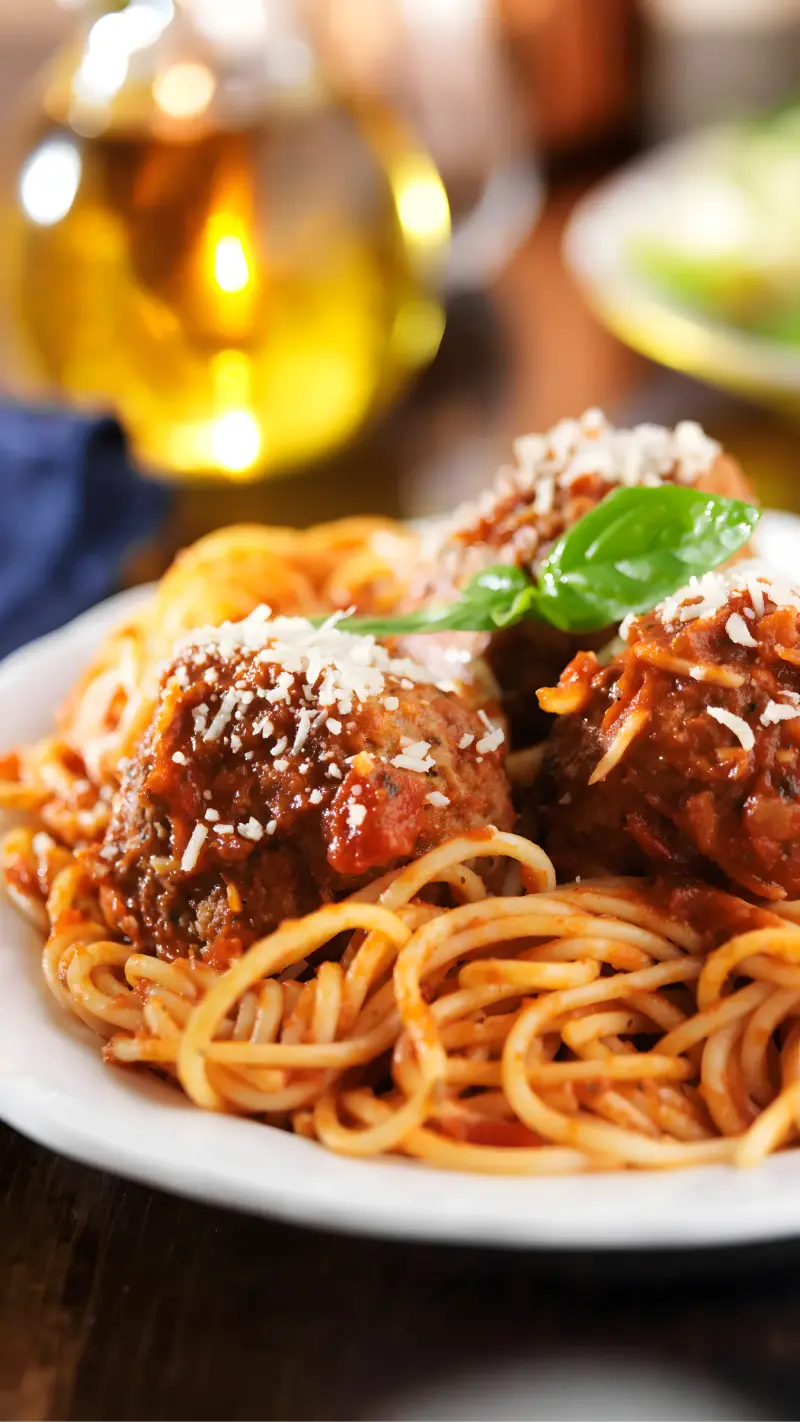 Spaghetti and meatballs topped with parmesan and basil