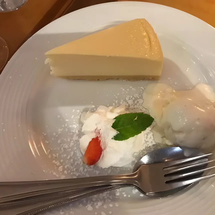 Cheesecake with whipped cream, strawberry, mint and vanilla ice cream.