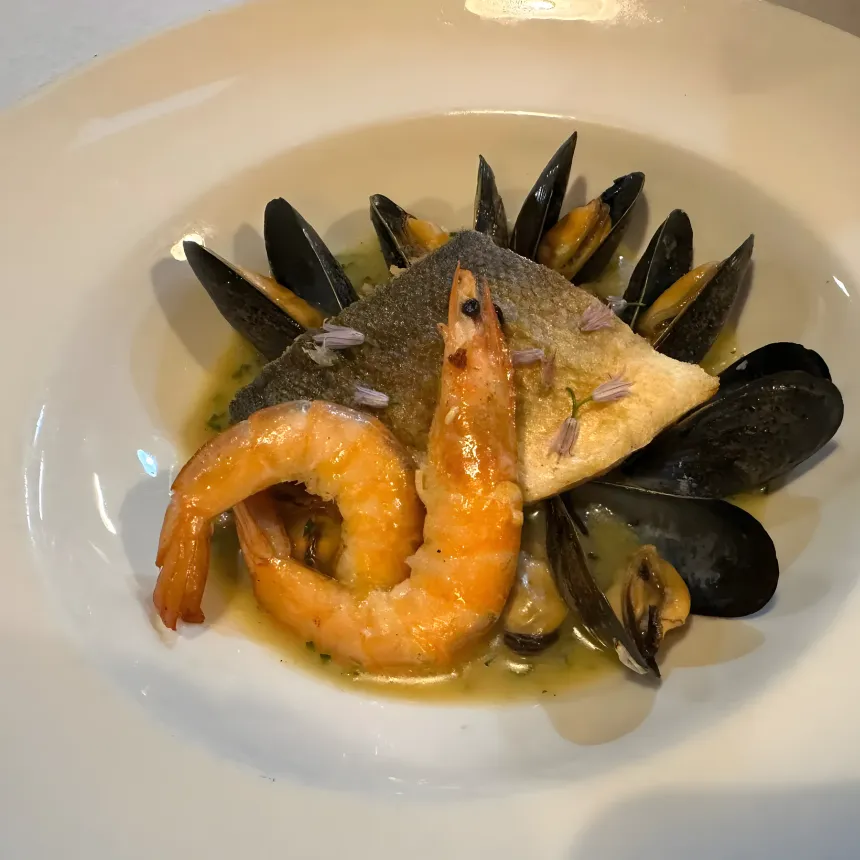 Grilled fish fillet, prawns and mussels with a light sauce.