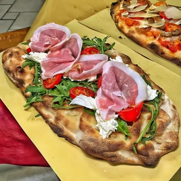 A flatbread with rocket, cherry tomatoes, mozzarella and prosciutto.