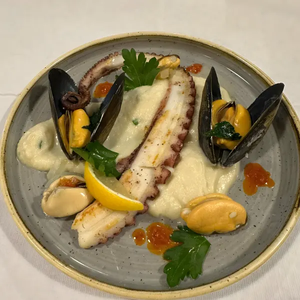 Grilled octopus tentacles and mussels on a creamy purée.